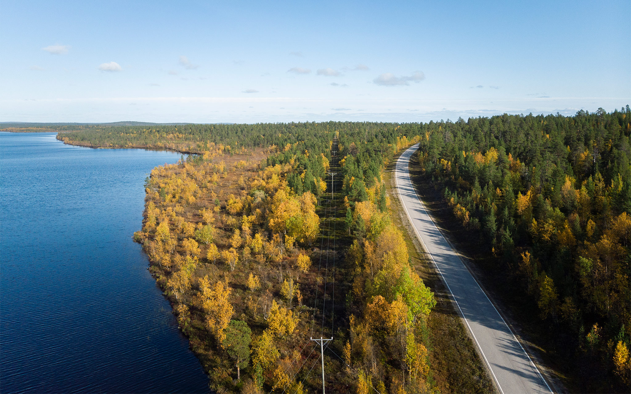 Tie ja sähköverkkoa halkoo lapin metsää.