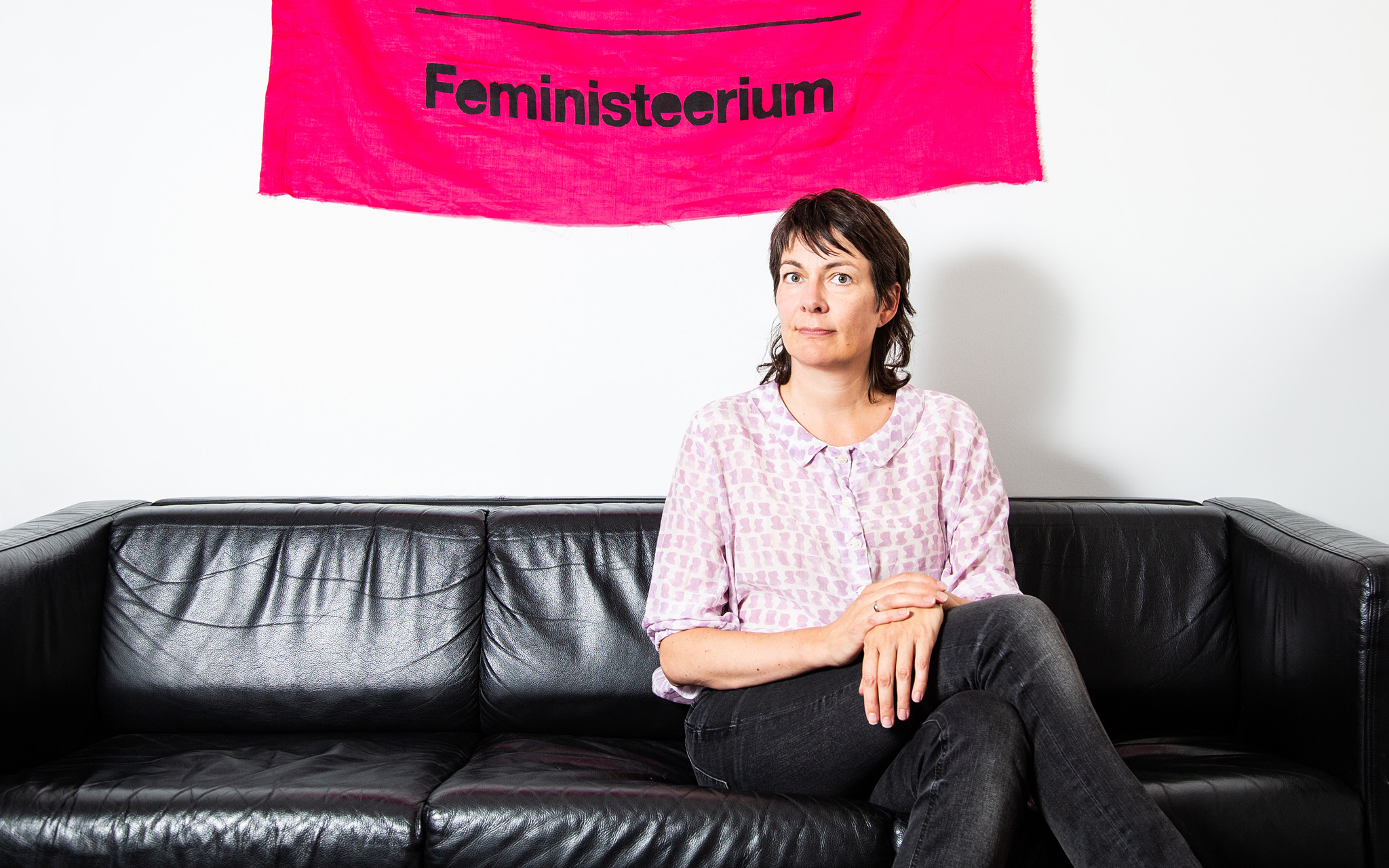 Nainen feministibanderollin edessä