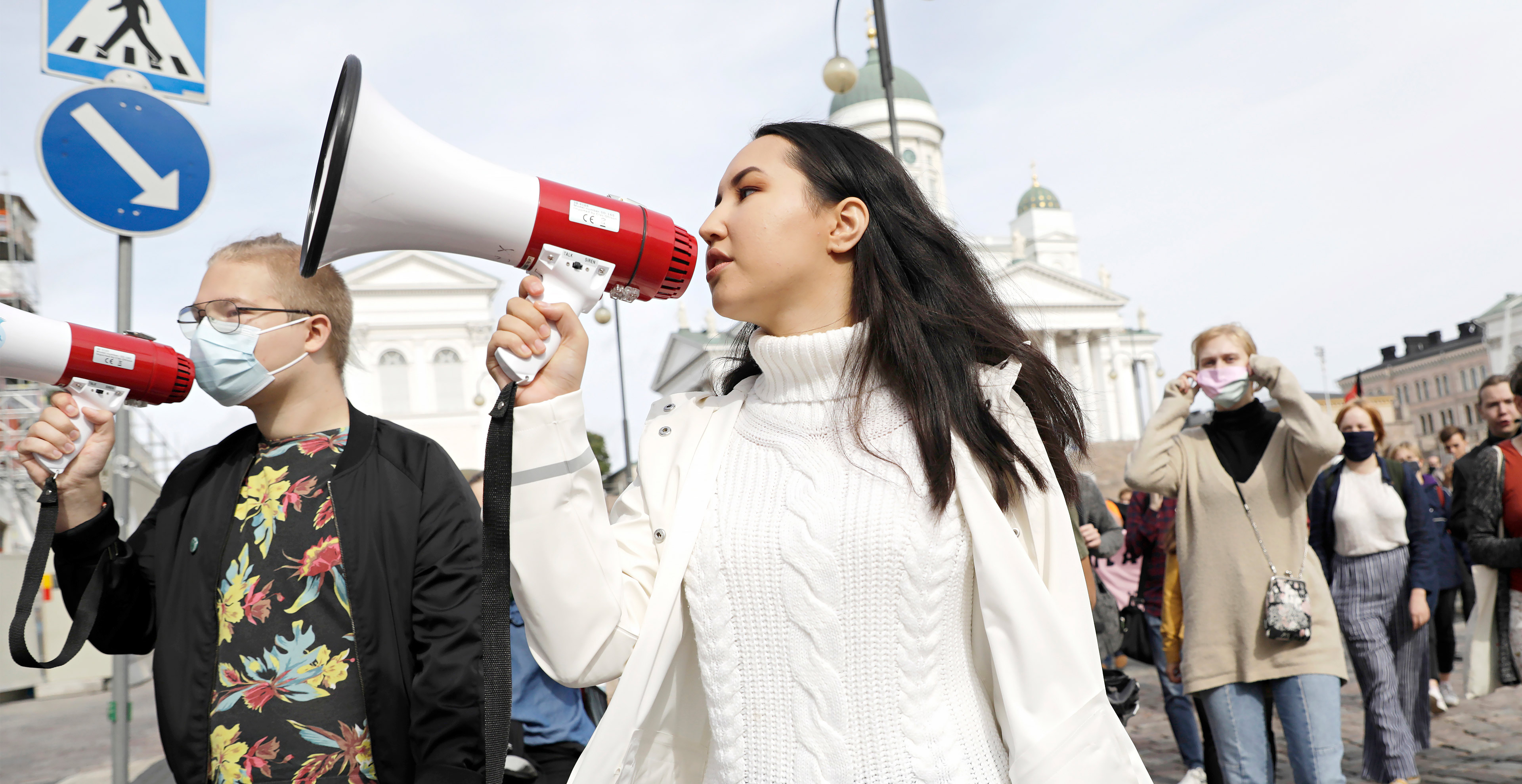 Zahra kulkee Senaatintorilla mielenosoittajien kanssa kovaääninen suunsa edessä.